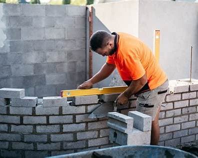 Bricklayer checking level on block wall